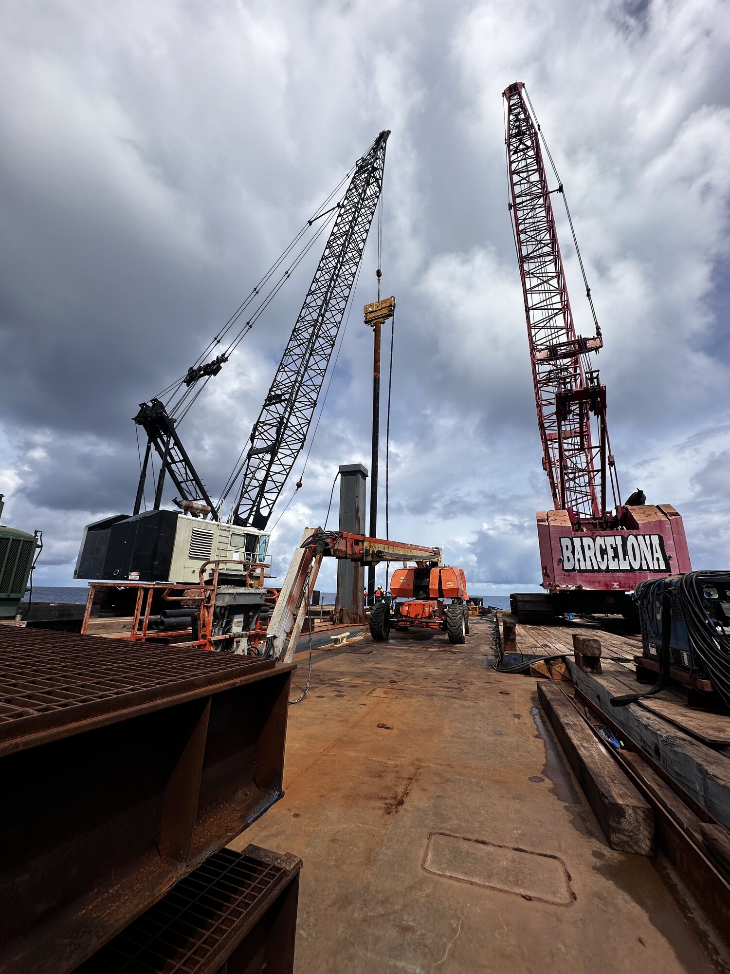 Two cranes working at barge construction site